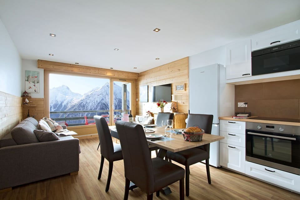 Bright alpine living space with mountain views through picture windows