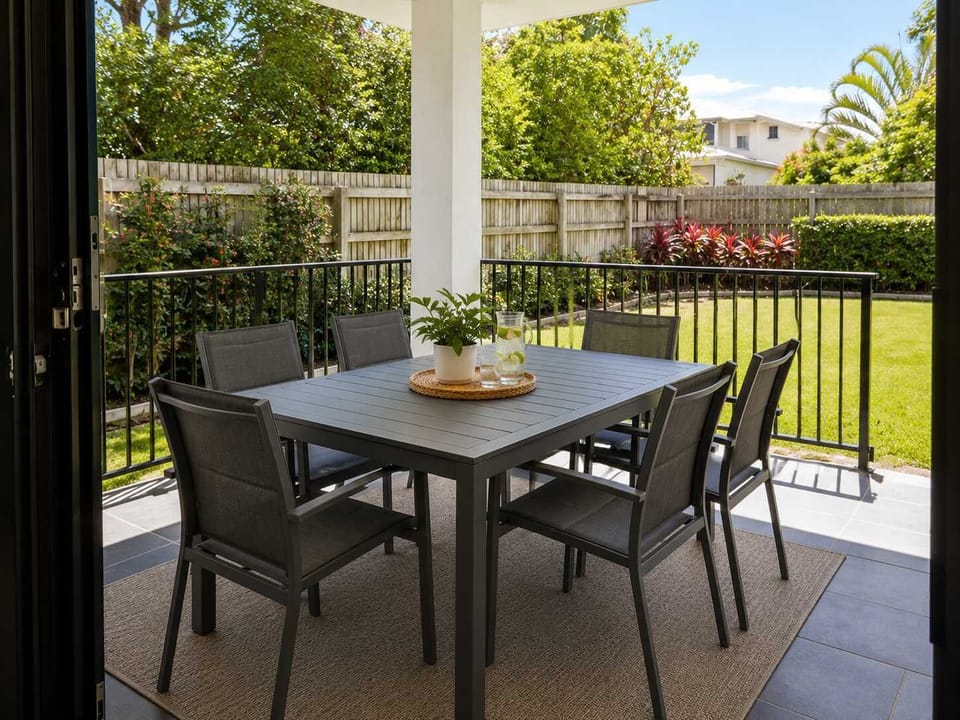 Covered outdoor dining area overlooking the backyard