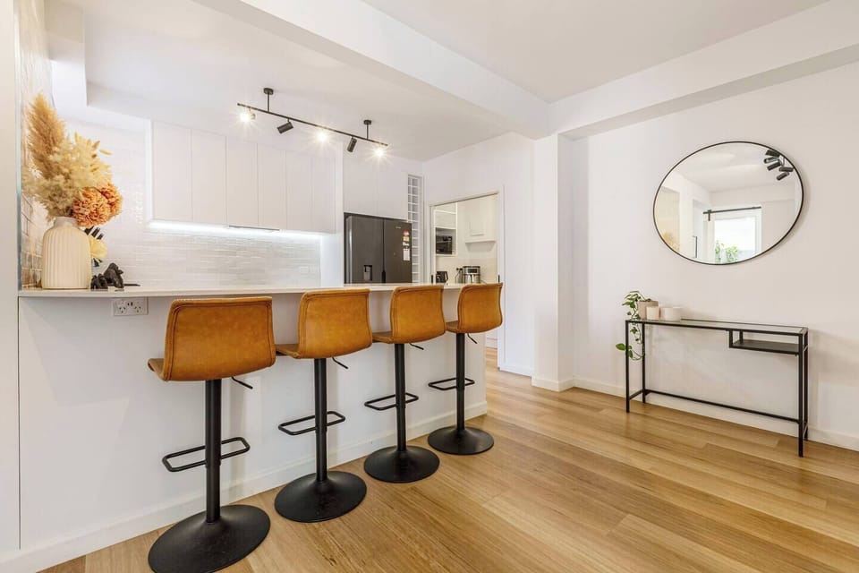 The kitchen bench with stools doubles as a relaxed dining spot for easy breakfasts, light meals, or a quick bite before heading out to nearby Chapel Street.