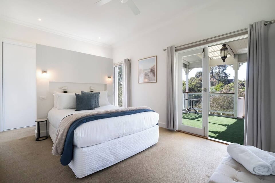 The primary bedroom invites you to unwind with a comfortable queen bed, ensuite, and direct access to the balcony overlooking tranquil, leafy surrounds.