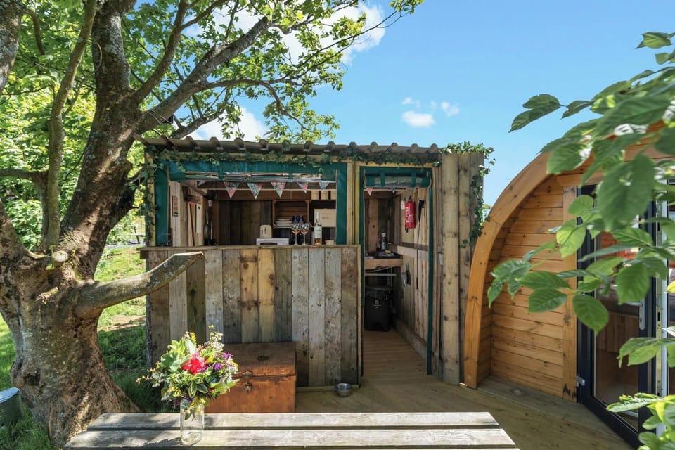 Wooden cabin-style patio with table, chairs and flower bouquet