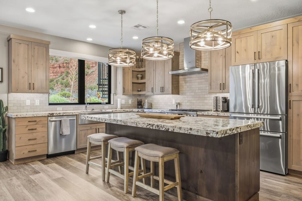 Bright gourmet kitchen with granite island seating and stainless appliances at Grand Kanab'n