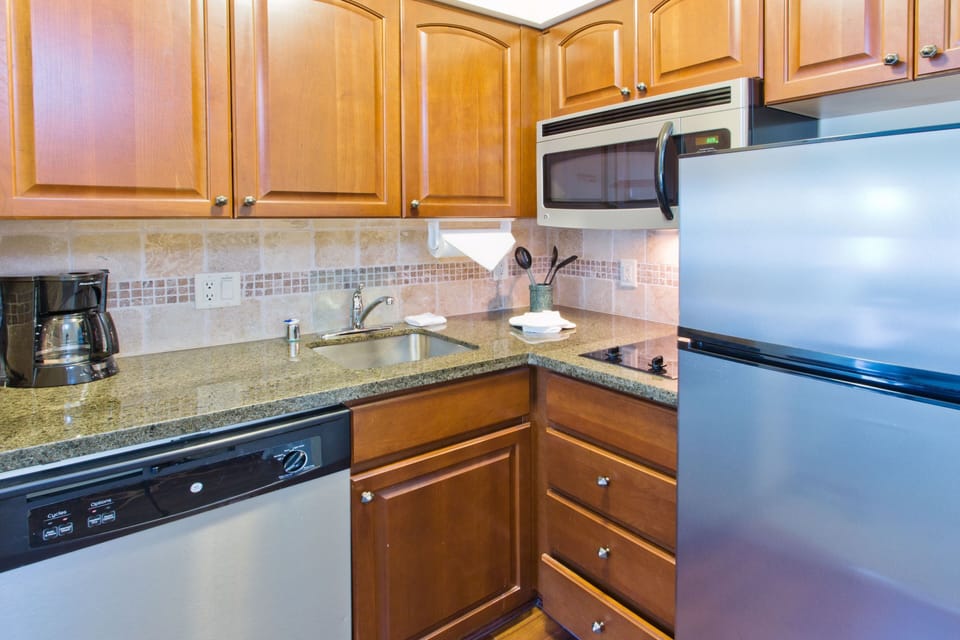 Modern kitchen featuring wooden cabinets and appliances.
