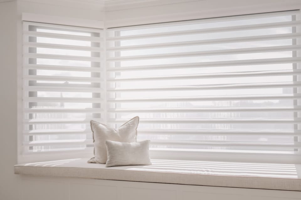 A cushioned window seat in one of the bedrooms
