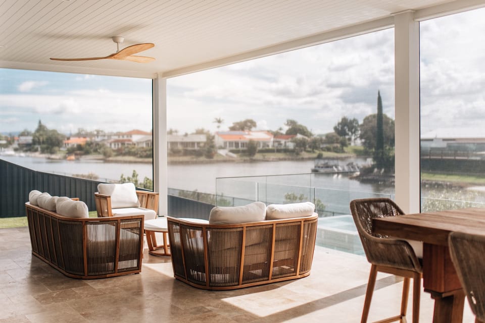 The covered alfresco holds an outdoor lounge, dining and kitchen above the water