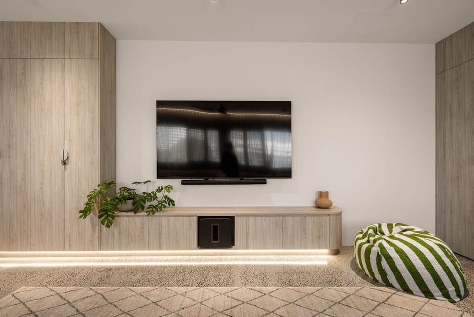 The screen wall and joinery, with floor lighting under the cabinetry