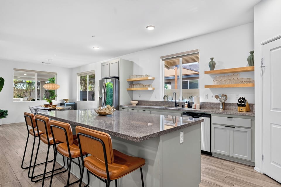 Modern kitchen featuring a large central island with barstool seating.