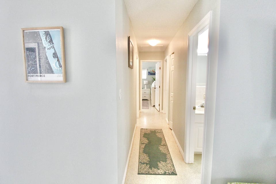 The hallway leading to the hall bathroom, first door on the right and the 3 bedrooms.