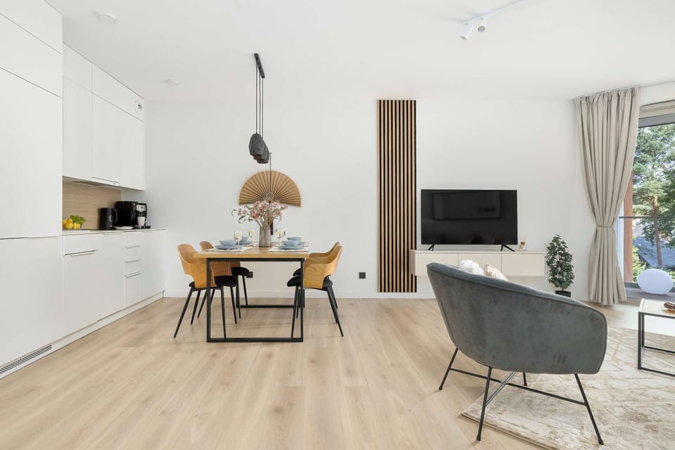 The bathroom features a walk-in shower area with a rain shower head, a large white radiator, and smooth grey wall tiles.