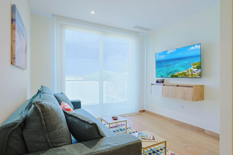 Relax in this bright and inviting living area, where comfortable seating and a Smart TV with IPTV channels create the perfect space to unwind after a day of exploring Aruba.