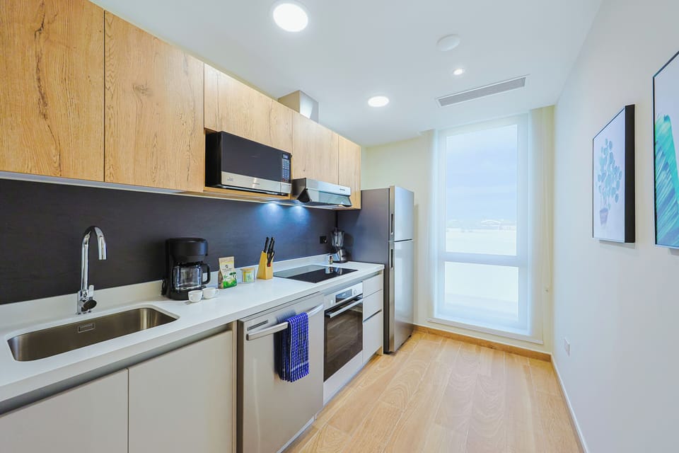 Your fully equipped kitchen awaits with sleek countertops, modern appliances, and warm wood finishes—perfect for whipping up a quick breakfast or preparing a leisurely meal during your stay.