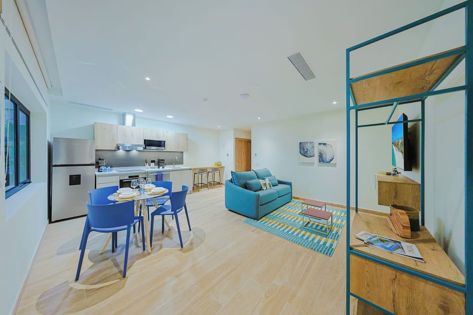 Step into your bright, open living space where vibrant blue seating and a fully-equipped kitchen invite you to relax and enjoy effortless vacation living.
