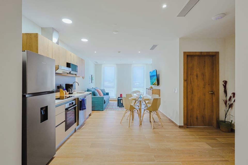 Your bright, open-plan living space flows seamlessly from kitchen to dining to relaxation, with warm wood tones, modern appliances, and plenty of natural light—everything you need to feel at home.