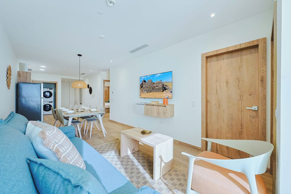 Bright, airy living space with coastal vibes, natural wood accents, and an inviting blue sofa where you can unwind after a day of adventure.