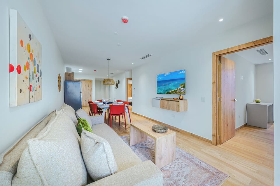 Settle into your bright, open living space where natural wood tones and airy design create an instant sense of calm. The plush sofa invites relaxation, while the adjacent dining area is ready for shared meals and laughter.