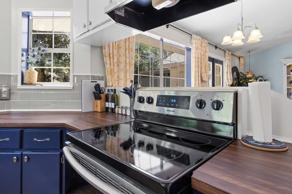 Cook up fresh catches on the stainless Samsung range, with a full knife set and sunny window light keeping the space bright.