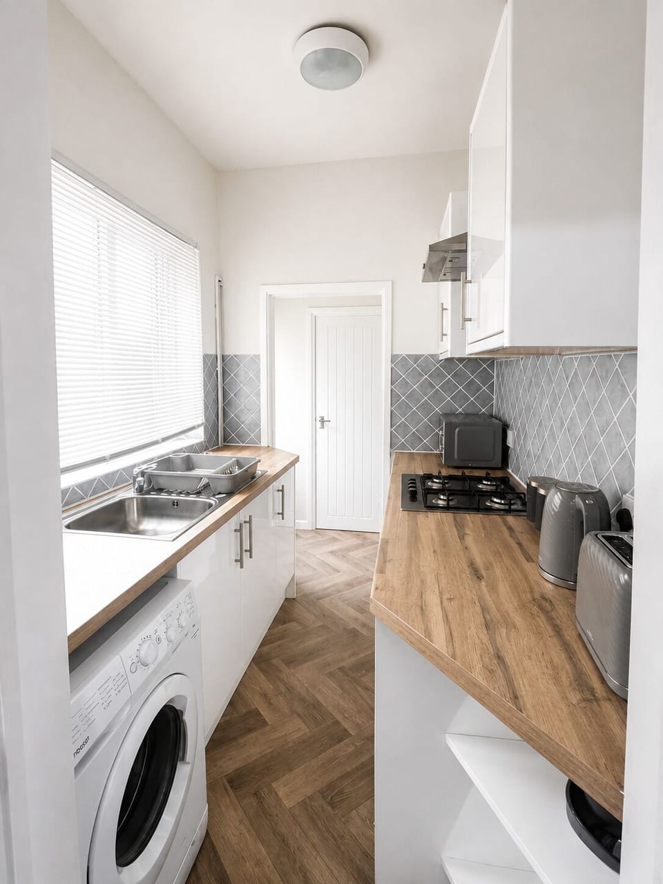 Bright modern kitchen with washer, gas hob, and plenty of prep space