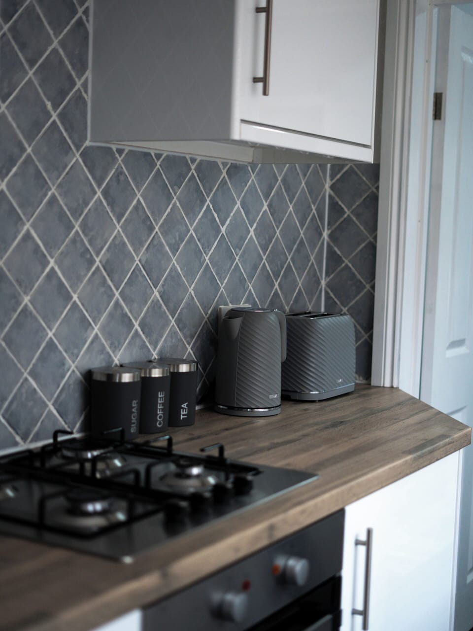 Modern kitchen with stylish tile backsplash and well-equipped countertop