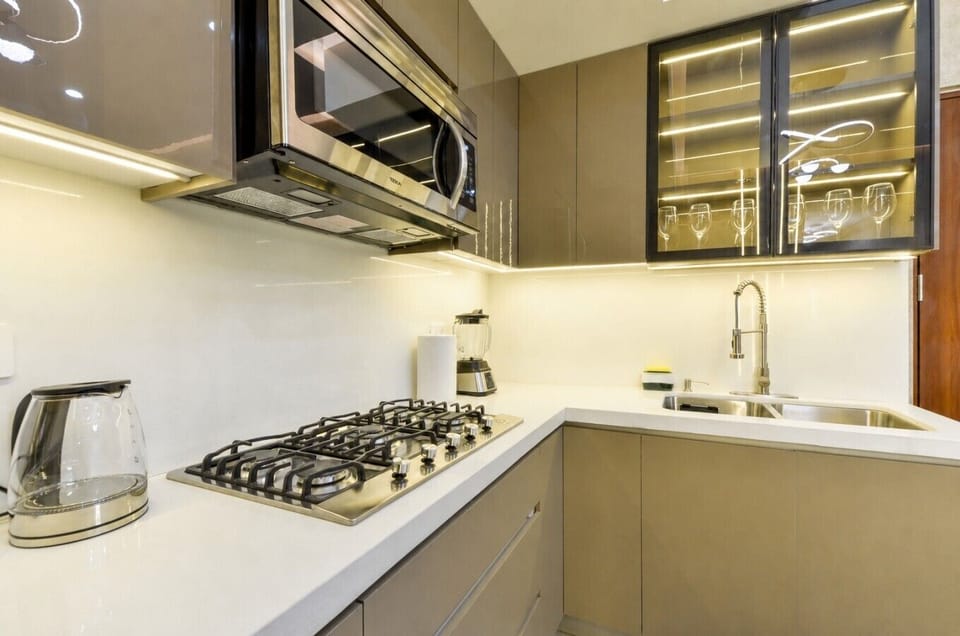 Cocina equipada con refrigerador, microondas, estufa y todos los utensilios necesarios para preparar tus comidas con facilidad.