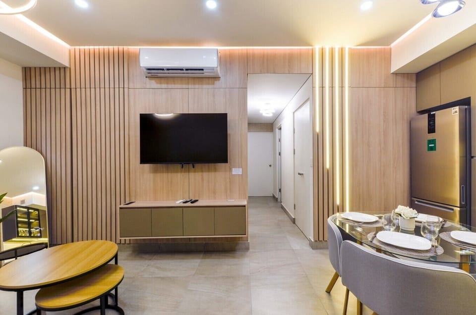 Sala principal con aire acondicionado, Smart TV, sofá cama y mueble de TV. Un espacio cómodo y fresco para relajarte y descansar.