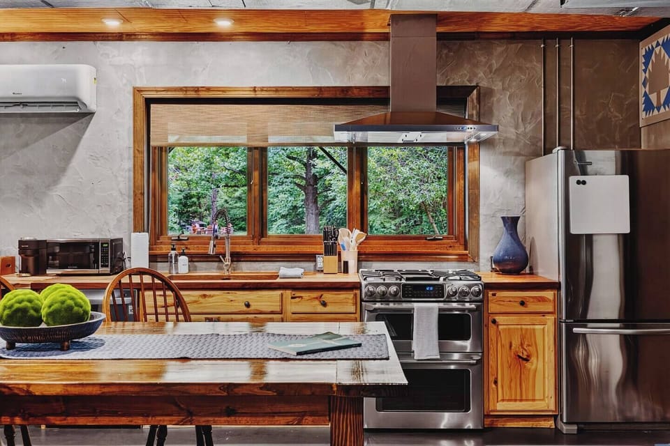 Fully equipped Garden Suite kitchen with modern appliances, a spacious island, and a beautiful view of the surrounding greenery.
