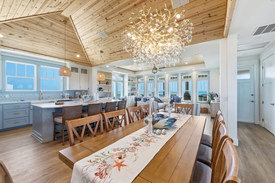 Elegant coastal retreat with soaring vaulted wood-plank ceilings, a stunning statement chandelier, and chef’s kitchen. Panoramic ocean views and a spacious dining area create the perfect setting for gathering and relaxing.
