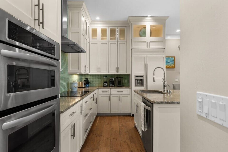Bright gourmet kitchen with island, granite counters, and stainless appliances