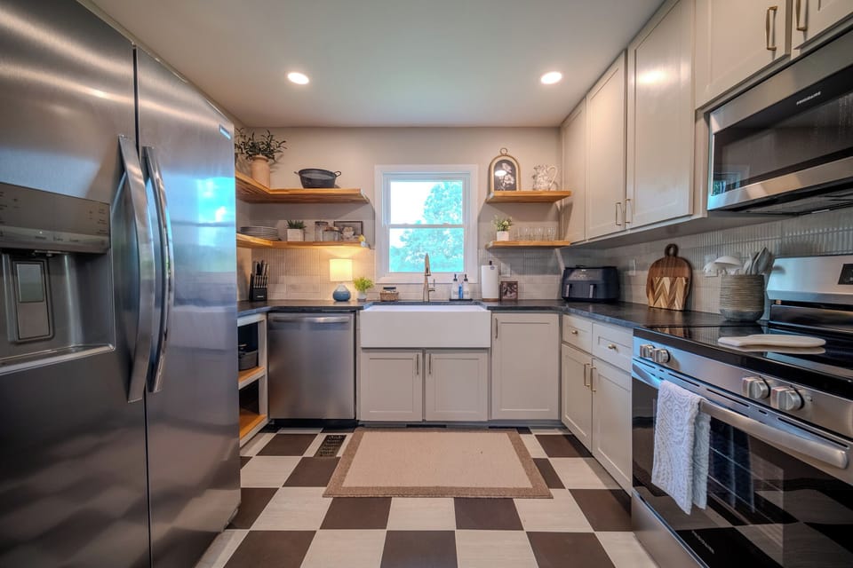 Bright, fully equipped kitchen with open shelving, modern appliances, and everything you need to prepare meals during your stay.