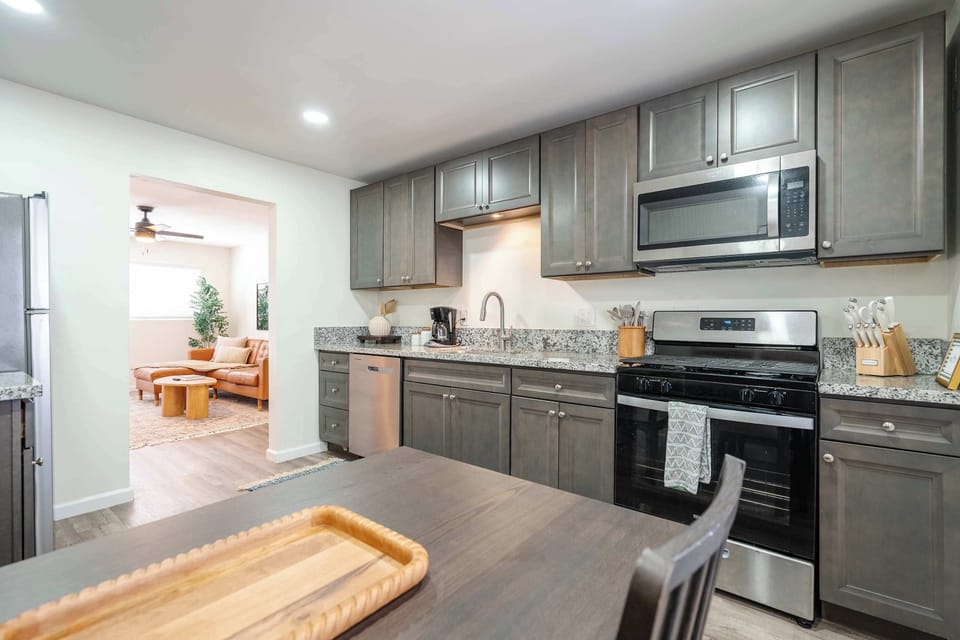 Full kitchen with stove, oven, microwave, refrigerator, cookware, and dining essentials.