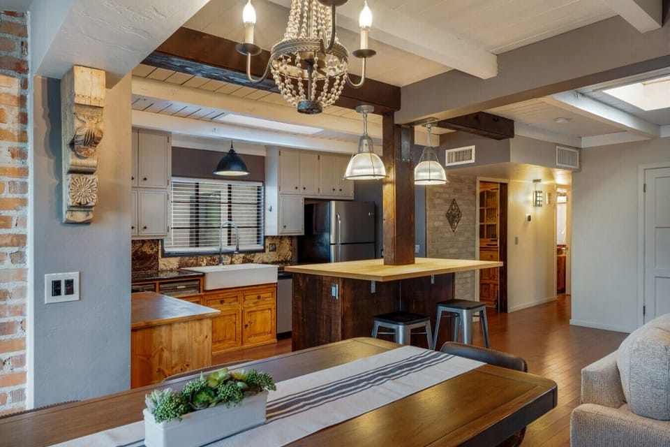 Gather Round the Table — A long farmhouse table sits right off the kitchen, so whoever`s cooking never misses the conversation