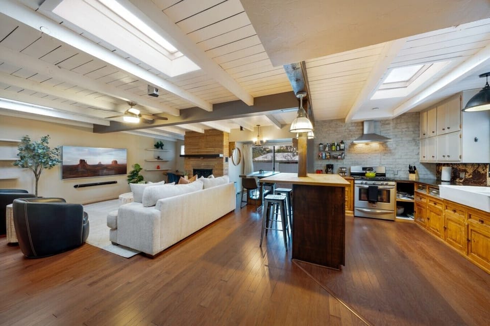 Bright and Open — Skylights and beamed ceilings pour light over the whole living-dining-kitchen space — it never feels closed in