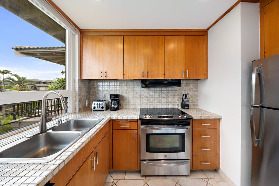Wake up to ocean views from the king-bed primary suite featuring direct lanai access and a private ensuite bathroom.