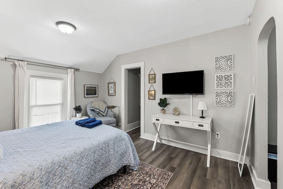 Wind down with a mounted TV and a well-appointed console, all set against warm wood flooring.