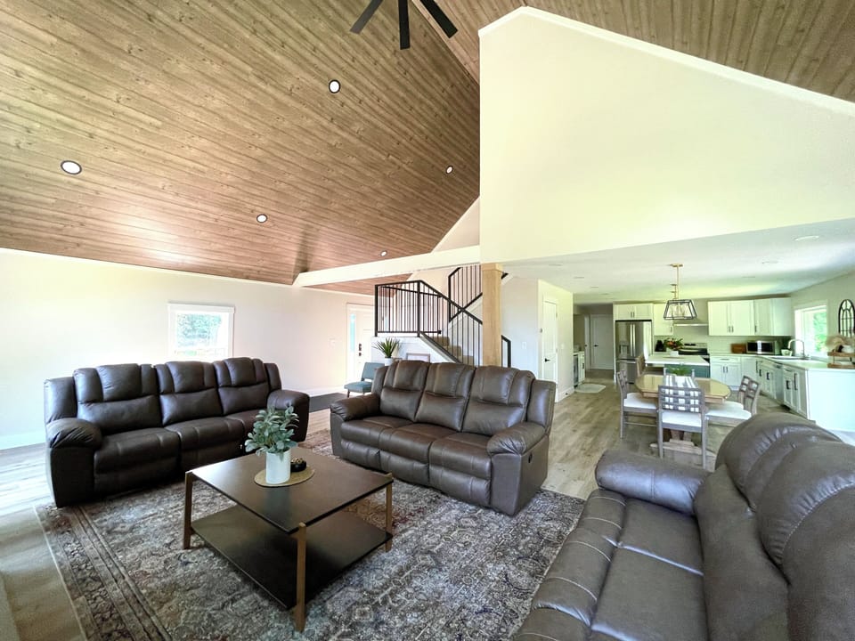 Take in the soaring wood ceiling and spacious open layout, then claim a reclining seat for relaxed evenings with your favorite people. 🛋️🌲