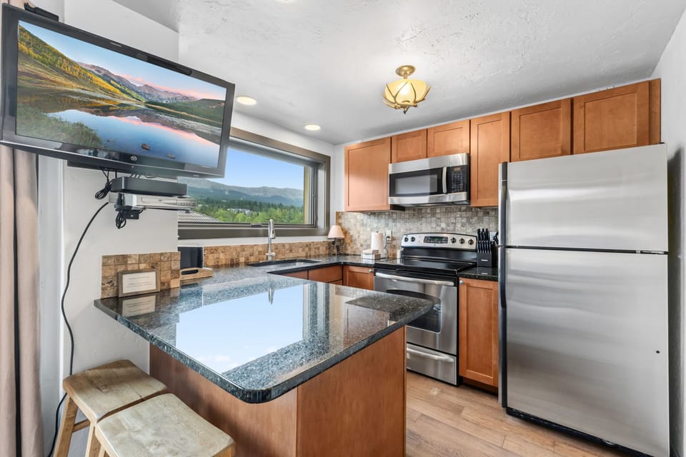 Enjoy preparing meals in your fully equipped kitchen with granite counters, stainless appliances, and a breakfast bar for casual dining. The TV lets you catch up on your favorite shows while you cook.