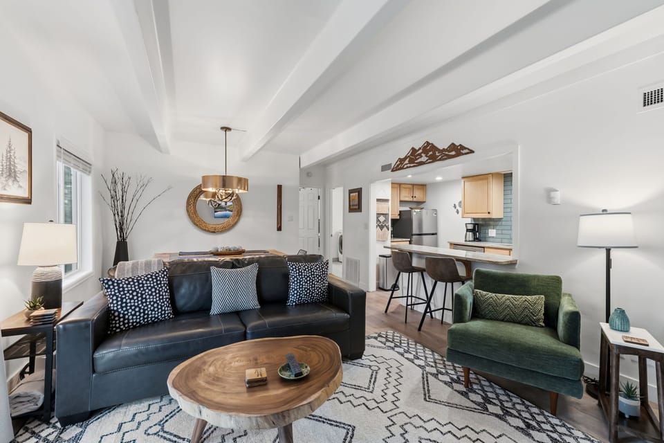 Sink into the sleek leather sofa and unwind in your open-concept retreat, where vaulted ceilings and mountain-inspired accents create an airy, welcoming atmosphere perfect for relaxing after a day of adventure.