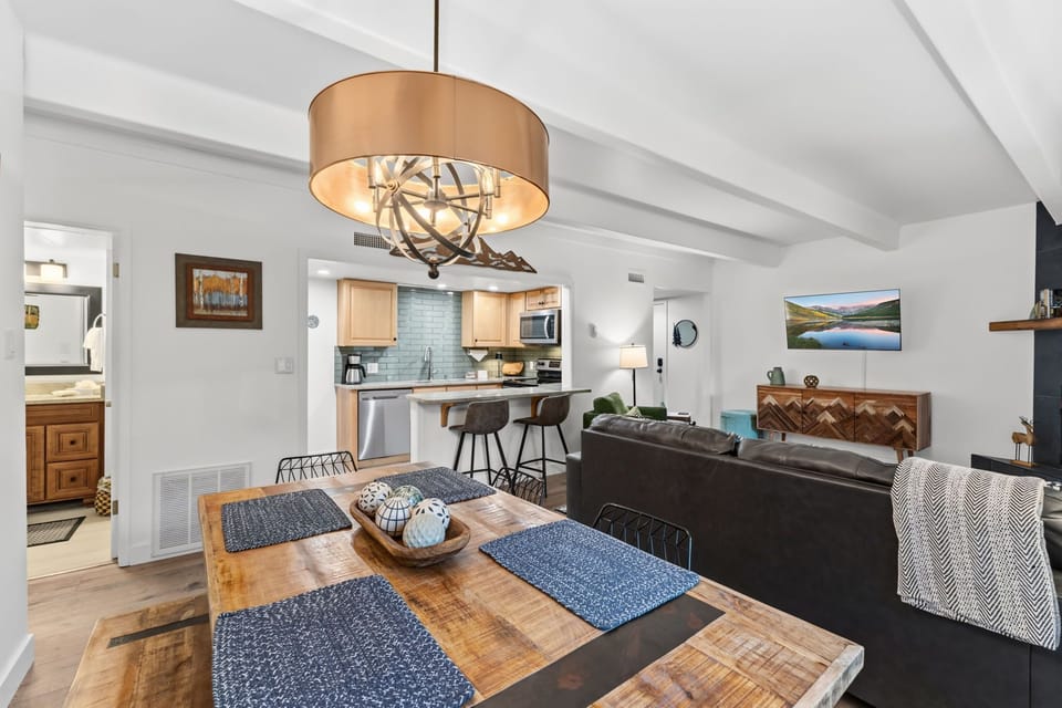 Gather around the custom wood dining table or unwind on the plush leather sofa, where rustic charm meets modern comfort. Your open-plan retreat features a beautifully appointed kitchen and warm, inviting touches throughout.