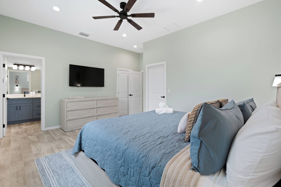 Guest bedroom 1 features extra storage and a mounted tv