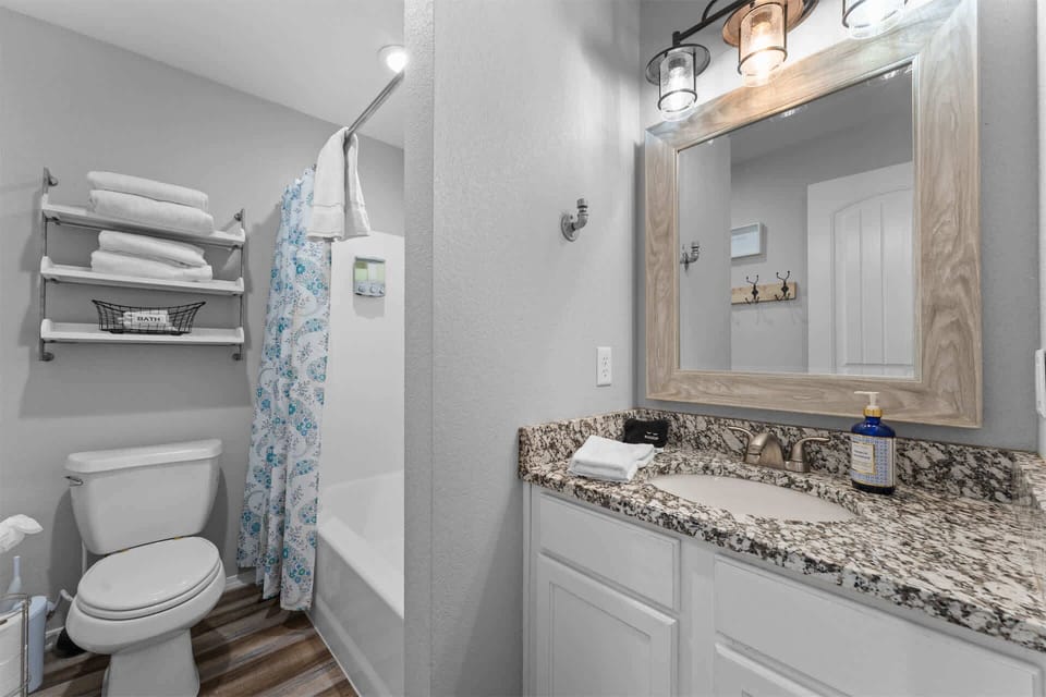 A convenient shared bathroom featuring a versatile shower/tub combo