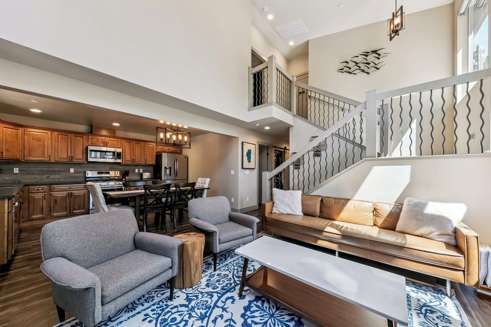 Sink into plush seating and enjoy your vacation in this stunning open-plan space, where the fully-equipped kitchen and soaring two-story ceiling create an airy, welcoming retreat for gatherings.