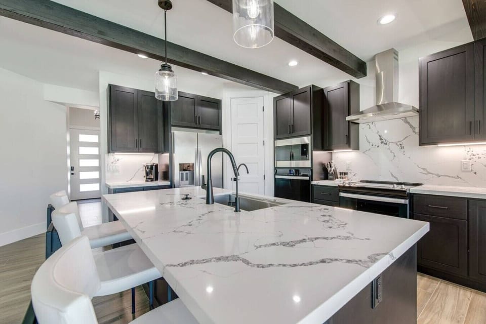 Fully equipped kitchen with sleek cabinetry, stainless steel appliances, and a large island.