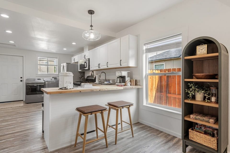 Light and bright open kitchen with two barstools for additional seating
