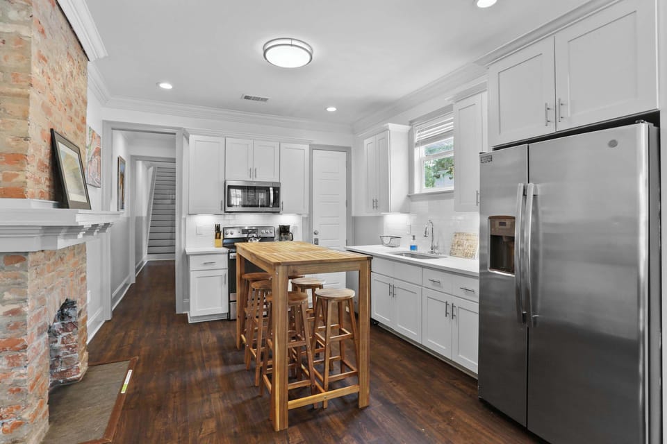 Fully equipped kitchen with stainless steel appliances, generous counter space, and a large island with seating for casual meals and conversation.