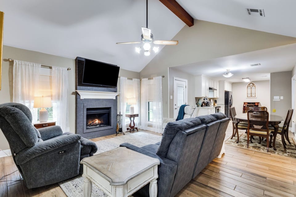 Open living room with fireplace, recliners, vaulted ceilings & dining area