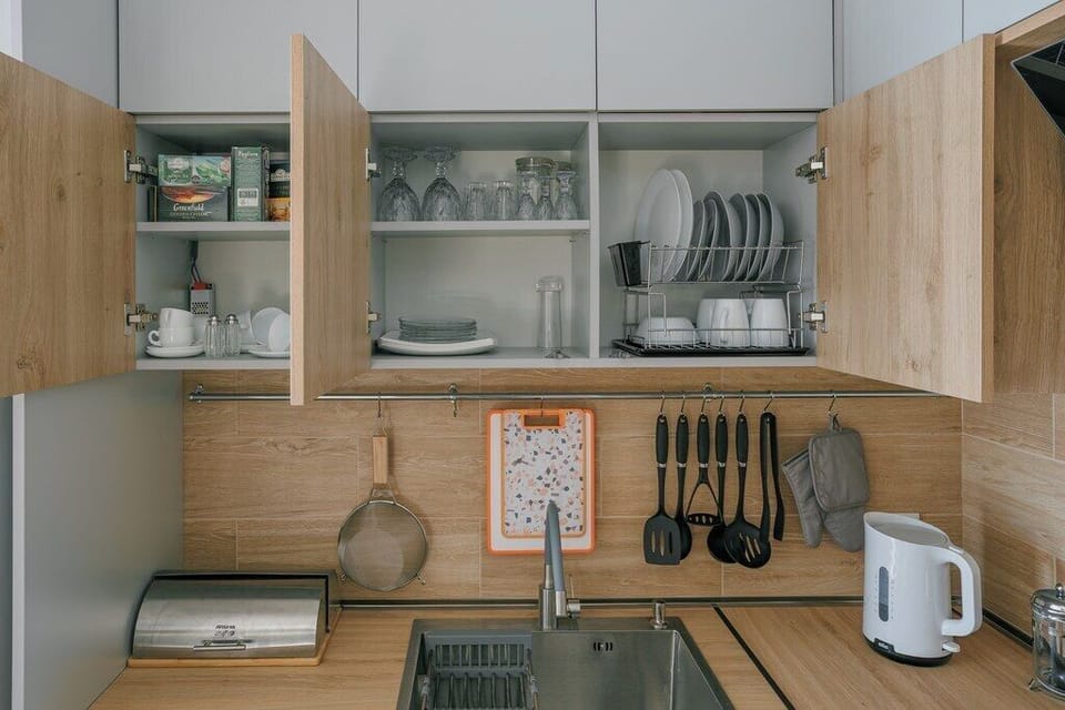 Kitchen with open cabinets showing the full set of cookware and tableware.