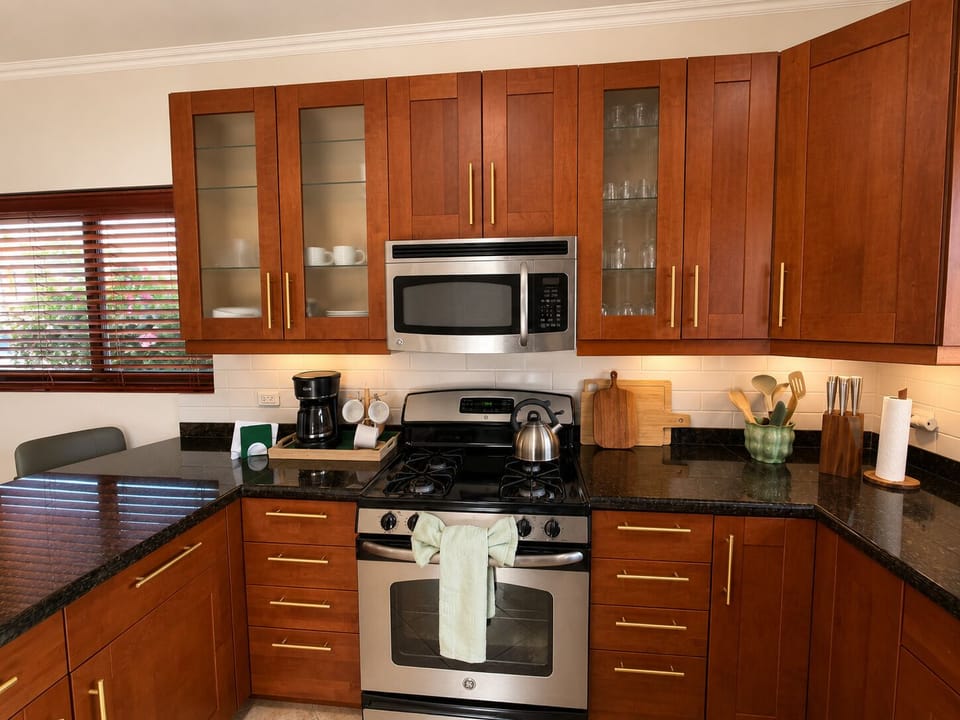 Cook up a feast in this fully equipped kitchen boasting rich wooden cabinetry and stunning dark granite countertops.