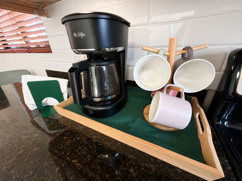 Start your day right with our dedicated coffee setup, complete with a drip brewer and cozy mugs.