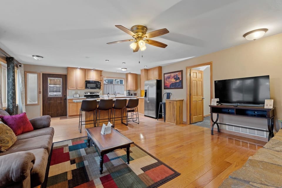 A spacious open-concept living area seamlessly connecting the comfortable lounge, entertainment space, and fully equipped kitchen with island seating.