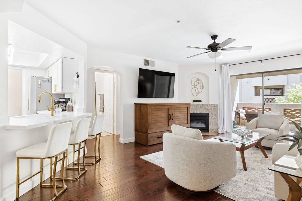 Bright open living space with fireplace, breakfast bar, and private balcony