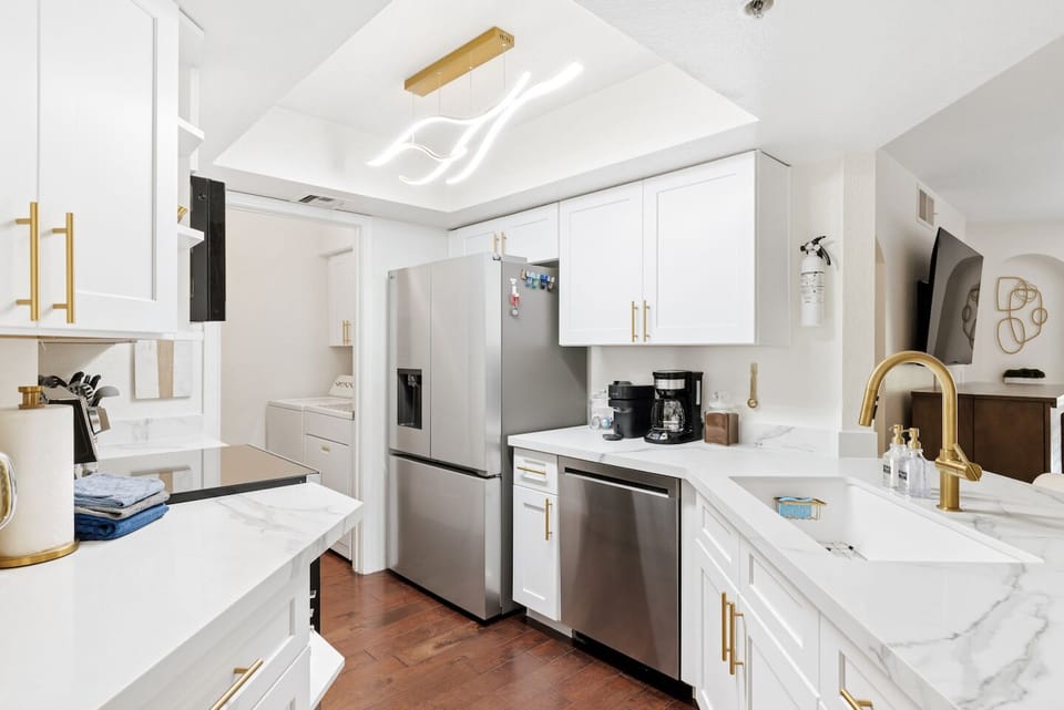 Bright modern kitchen with stainless appliances and elegant gold accents